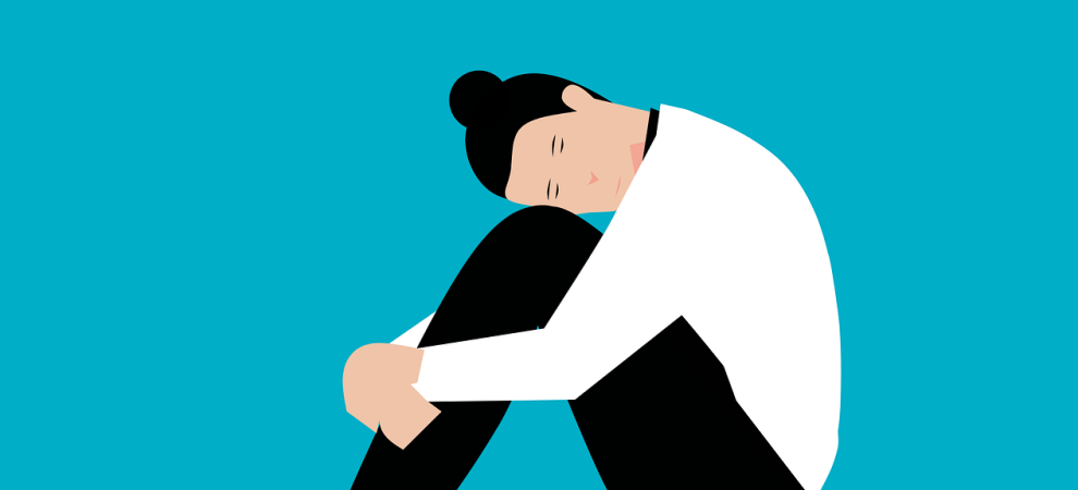 Graphic of a person with head on their knees being anxious